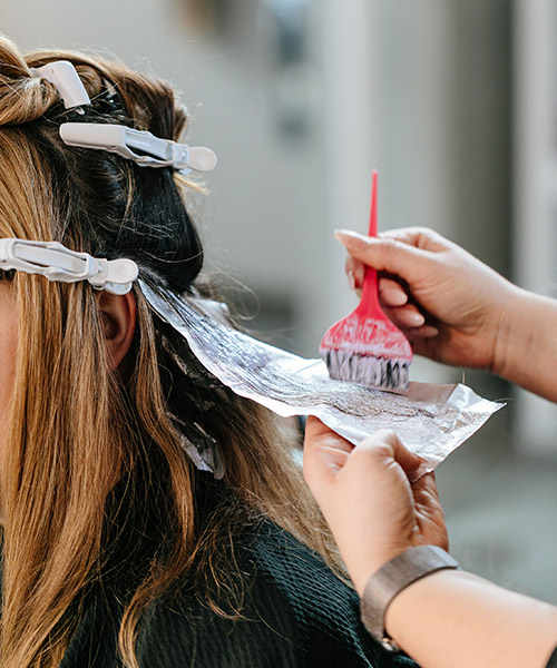 Brown haired girl getting her hair colored to a darker color