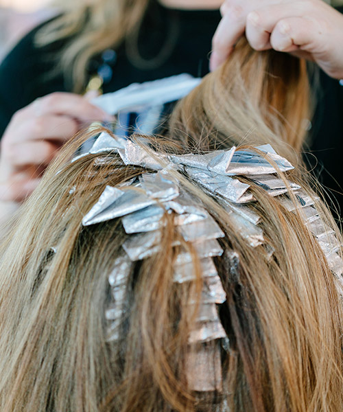 Blond haired girl getting highlights in her hair