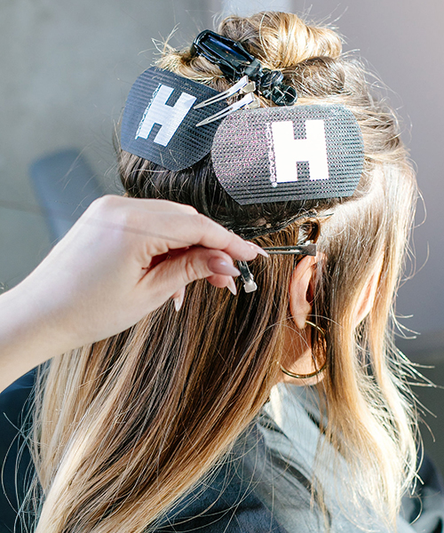 Dirty blonde haired girl getting extensions installed